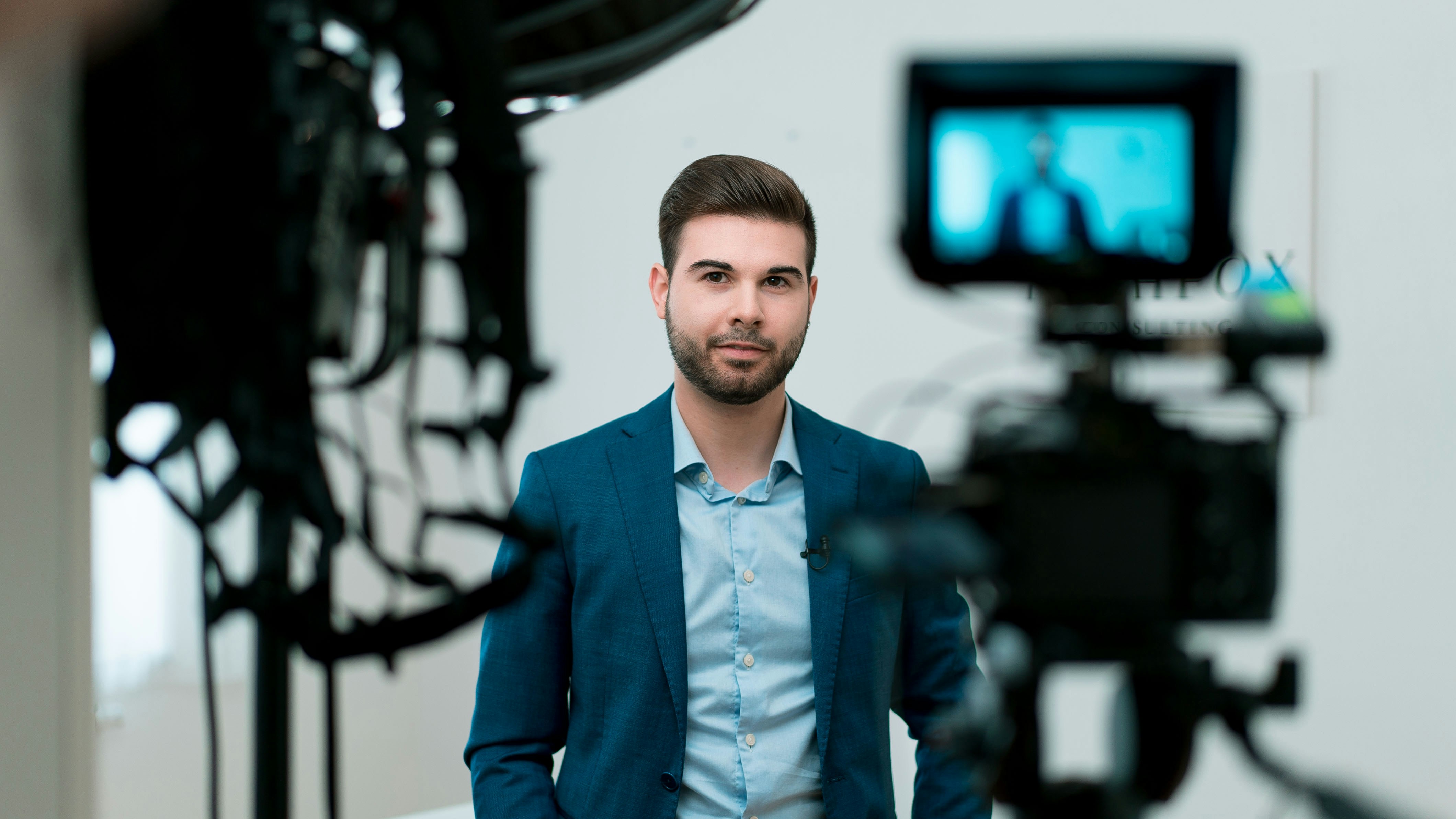 Man with dark hair and beard looking at camera in a studio