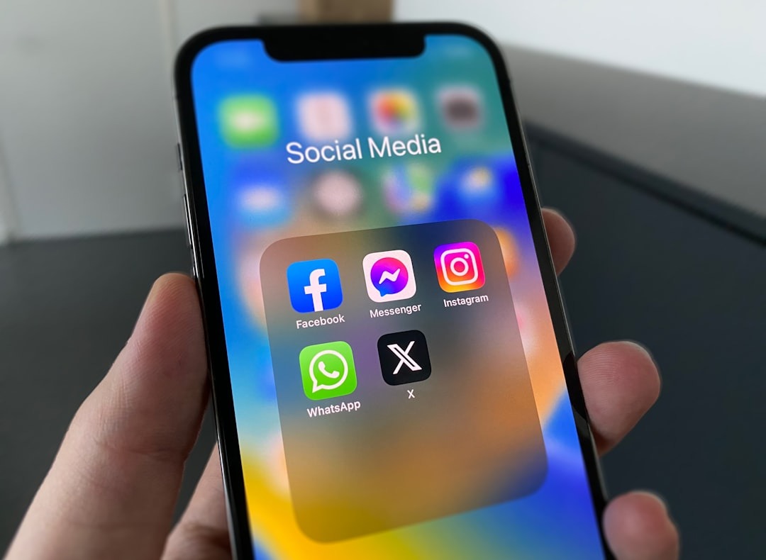 close up of hand holding phone with social media title and logos of platforms