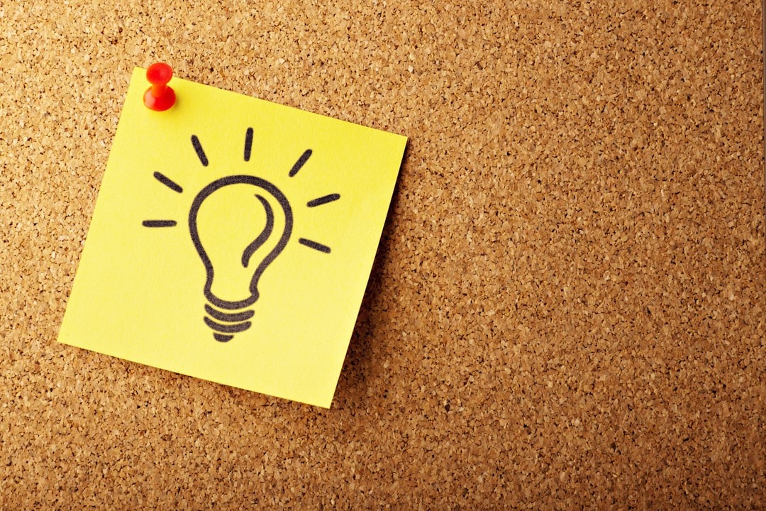lightbulb drawn on yellow sticky post stuck on cork pinboard