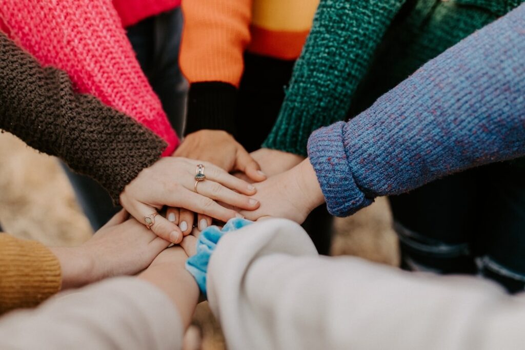 group of people with only arms and hands visible connecting hands ontop of each other